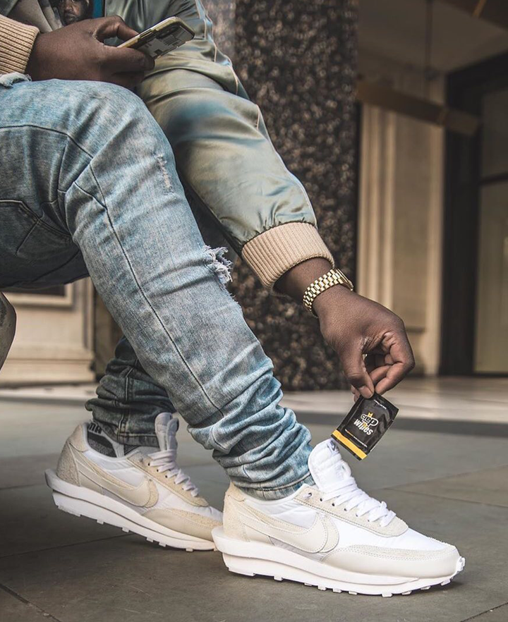 Man Holding Crep Protect Wipes Next to His Clean Sneakers for Maintenance