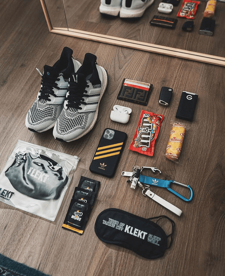 Pair of sneakers placed beside a comprehensive sneaker cleaning kit