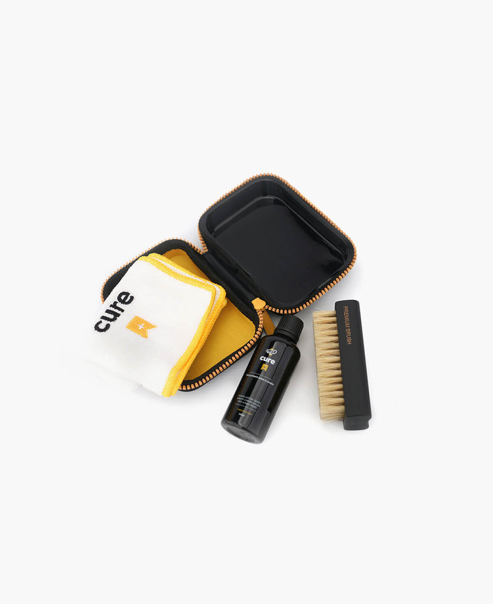 Cure Travel Kit, including cleaning solution, brush, and cloth for on-the-go sneaker maintenance