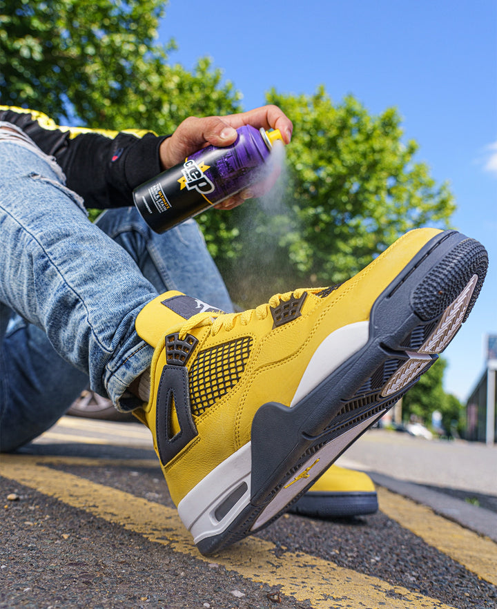 Man applying Crep Protect rain and stain resistant shoe protective spray on sneakers.
