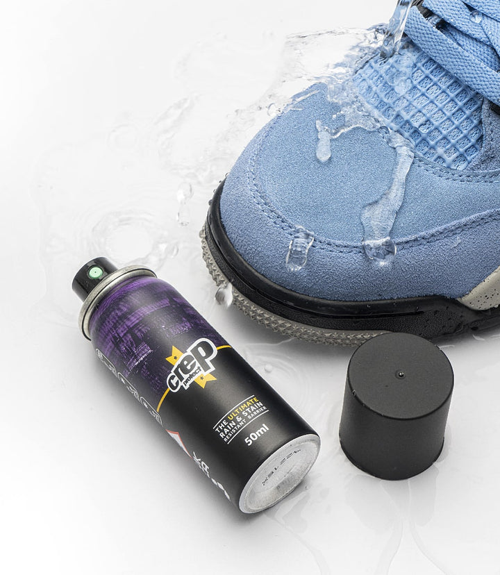 Bottle of Crep Protect rain and stain resistant shoe protective spray standing next to a sneaker.