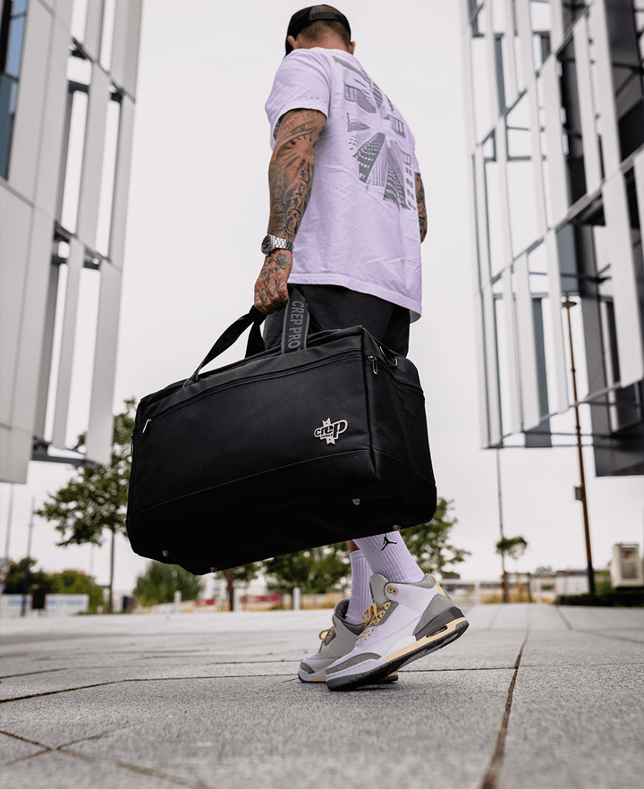 Man carrying a Crep Protect sneaker bag, ready to transport footwear with ease.